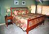 This bright and sunny upstairs bedroom features a king size bed, side chairs, walk-in closet, attached bathroom with jacuzzi, as well as a fantastic river view.