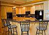 Big open kitchen with bar stools and granite counter tops.
