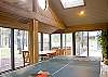 The Sunroom has a ping pong table, dining area, and a door to the outside deck.