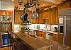 This kitchen also includes a wine refrigerator, a gas range and a side by side upright refrigerator.