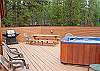 This large back deck has plenty of seating, a BBQ, picnic table and a relaxing jacuzzi.