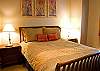 This Queen Bedroom is decorated in warm colors.