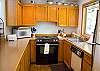 The kitchen has a new Jenn Air range. This galley style kitchen has a breakfast bar and is open to the dining room.