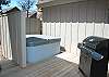 Deck with private hot tub and large propane grill.