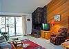 The living room has a wood fireplace and a  flat screen television.