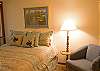 The downstairs bedroom features a queen size bed. Bedroom shares an attached hall bathroom.