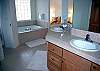 Upstairs Master Bathroom features a deep jacuzzi tub, double vanity sinks, and a spacious walk-in closet.