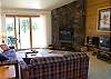 The living room is well lit with a nice rock fireplace.