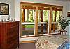 The downstairs queen bedroom is cozy and features floor to ceiling glass for a view of the yard and river. The bathroom is right next door in the hallway.