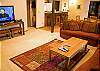 The living room has a large sectional sofa and flat screen TV.