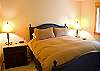 A master suite downstairs with a queen bed and a flat screen TV