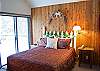 Sweetly decorated upstairs Loft Queen Master Bedroom overlooks the main living area downstairs. Sliding glass door leads outside to the upstairs balcony.