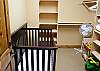 This is a very large walk in closet in one of the king masters downstairs that has a full sized crib.