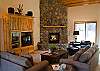 Cozy leather furniture, a picturesque river rock fireplace, and high vaulted ceilings adorn this spacious living area. Living area has door access out onto back deck.