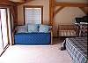 View number 2 of the second main bedroom within the Round Mountain Lodge.  The sliding glass doors open up and look out at Mount Lafayette and the greater White Mountain National Forest beyond.
