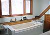 The master Suite bathroom feature a separate standing shower in additon to this grand sitting tub which enjoys  outstanding and immediate views of some of the more major White Mountains that NH has to offer.