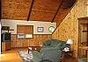 This angle of the living room shows the stairway that leads to the open loft style bedroom that offers one King size bed and one set of bunks and comfort for 4.  This home is perfect for a young family plus the grand parents, wouldn't you say.