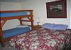 The lowest level of the Round Mountain Lodge features 4 bedrooms, one bathroom and the family game room.  Call this bedroom #1 bedroom featuring a queen bed, one bunk set and out of sight is a queen futon couch.