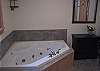 The master bathroom of the Kinsman Valley View is build in a keeping with the grand design of the home and features a 2 person jetted tub, seperate glass shower surround and granite counter topped vanities.