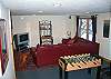 The lowest level of the Kinsman Mtn View enjoys a walk-out fully finished basement designed for nothing but entertainment.  Foos Ball, TV with DVD/VCR and game station as well a card-game table.  Kids of all ages just love it here!