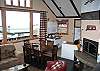 The main living area with fireplace hearth on one side and a serious wall of windows on the other.