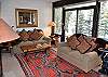 Living room with sliding glass doors out to the deck beside the Gore Creek