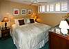 The bedroom at Surfside 405 has warm tones, shutters, and a king bed for your comfort.