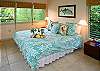 The master bedroom overlooks the front lanai and has windows on three sides, a king bed, and a private en suite bath.