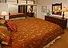 The bedroom has a queen bed and large mirrored-door closet.