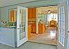 From the dining area step through French doors to the beautifully decorated living area, with the full kitchen just to the left.