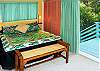 The bedroom has queen bed, ocean view, and sliding glass doors that lead out to the wraparound deck.