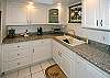 The kitchen has beautiful, custom cabinets and countertops.