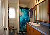 A standing shower and ocean decor are in the very clean master bathroom.