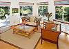 The living area is bright with beautiful furnishings, high ceilings, and views out to the tide pool.