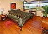 A great view, gorgeous wood floors, and a high quality queen bed and linens combine to create an inviting master bedroom at Mauna Loa Shores 506.