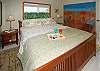The master bedroom upstairs has a king bed, TV, and en suite half bath.