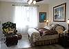 This bedroom has a comfortable Queen bed, relaxing arm chair and amazing views of Kapoho Bay.