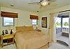 The other top-floor bedroom is light and cheery with a queen bed and an outdoor lanai.