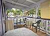 The front lanai (porch) doubles as a fresh air dining room with garden views.
