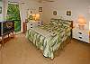 The master bedroom has a queen bed, en suite bath, and TV. It overlooks the garden area of the complex.