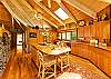 The open kitchen has a Sub-Zero refrigerator and other premium appliances including two convection ovens. The cooktop/breakfast bar countertop is made of a solid piece of monkeypod wood.