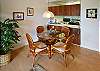 The dining area has a beautiful glass-top table and comfortable seating for four.