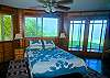 The Blue Bedroom Suite has doors out to the first floor oceanfront lanai and a full bathroom with shower over tub.