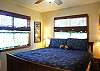 The master bedroom upstairs has a king bed, TV, and en suite half bath.