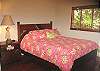 Queen size bed in one of the guest bedrooms.