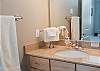 Two Luxurious Bathrooms With Granite Counters and Tile Floors