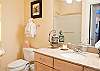Two Luxurious Bathrooms With Granite Counters and Tile Floors