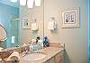 Two Luxurious Bathrooms With Granite Counters and Tile Floors