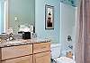 Two Luxurious Bathrooms With Granite Counters and Tile Floors