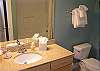 Two Luxurious Bathrooms With Granite Counters and Tile Floors
